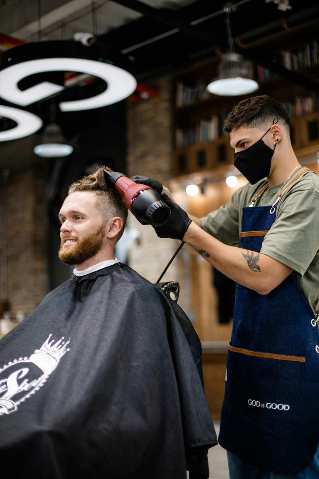 Barbero secando y peinando a un cliente